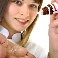 Apothekerin oder Ärztin mit homöopathischem Arzneimittel