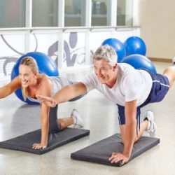 Mann und Frau machen gemeinsam Gymnastik im Fitnesscenter