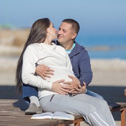 Werdende Eltern am Strand geniessen die Zeit.