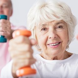 Ältere Frau und Mann arbeiten mit Hanteln.